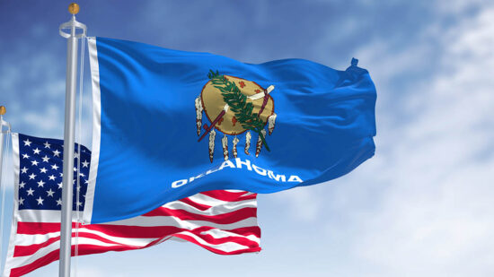 The Oklahoma state flag waving along with the national flag of the United States of America